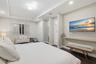 Tray ceiling with geometric flush-mount lighting, dark wood-finish flooring, recessed lighting, and a wall-mounted floating shelf