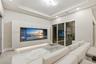 Living area featuring a tray ceiling with recessed lighting, custom floor-to-ceiling built-in media cabinetry with integrated lower illumination, and 
