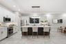 Kitchen featuring white shaker-style cabinetry, a contrasting dark-toned kitchen island with a light-toned solid surface countertop, stainless steel a