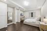 Bedroom featuring wood-finish flooring, tray ceiling with recessed and geometric modern lighting, and a wall-mounted floating display ledge