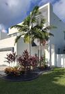 Contemporary two-story exterior featuring a white stucco facade with dark contrasting panels, horizontal sliding windows, and a segmented concrete dri