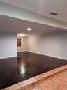 Sunken living area featuring dark wood-finish flooring, terra cotta tile steps, recessed ceiling lighting, and arch-top wall detailing