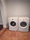 Laundry area featuring ceramic tile flooring and an arched architectural opening