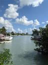 Waterfront property featuring a private wooden dock, direct canal access, and mature coastal vegetation
