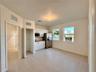 Kitchen featuring white cabinetry, stainless steel appliances, neutral tile flooring, and dual windows