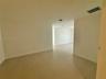 Neutral-toned ceramic tile flooring throughout the interior, complemented by smooth walls and high ceilings