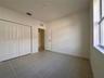 Neutral-toned ceramic tile flooring, built-in bifold closet doors, and a multi-panel interior door