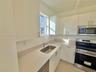 Kitchen featuring white cabinetry, solid surface countertops, stainless steel undermount sink, and stainless steel appliances