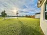 Backyard featuring a manicured lawn, water frontage, and wood privacy fencing