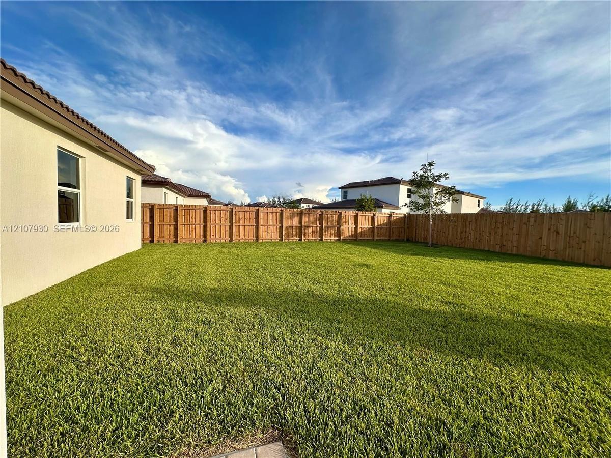 Expansive backyard featuring a level lawn and a wood privacy fence