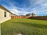 Expansive backyard featuring a level lawn and a wood privacy fence