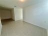 Interior space featuring neutral wall-to-wall tile flooring and crisp white walls