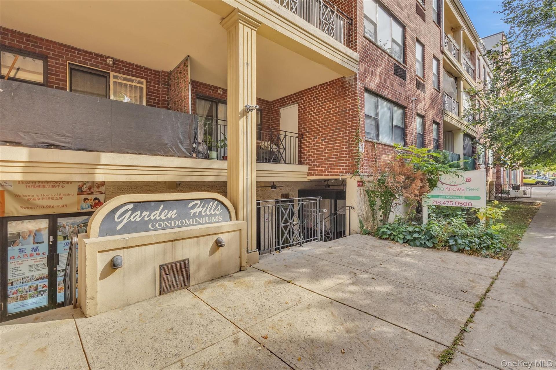 Brick exterior featuring a concrete facade, covered terrace, decorative column, and iron railings