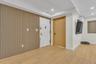 Wood-slat accent wall, light-toned wood-finish flooring, recessed ceiling lighting, and solid-core interior doors