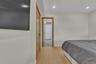 Light-toned wood-finish flooring, recessed ceiling lighting, and solid-core wood-finish doors
