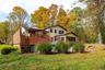 Expansive rear yard with a tiered wood-plank deck, stone-stepped pathway, and 4-Season Room