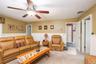 Interior space featuring wall-mounted wainscoting, carpeted flooring, and a ceiling-mounted light fixture with a fan