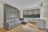 Built-in olive-toned cabinetry, wood-finish flooring, recessed lighting, and wall-mounted climate control unit