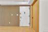 Vertical wood-slat wall paneling, white six-panel entry door with brass-finish hardware, wood-finish flooring, and solid-core interior door with match