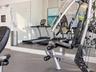 Fitness center featuring wall-to-wall mirrors and durable rubberized flooring
