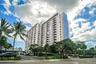 High-rise exterior featuring multi-level private balconies, white structural facade, and accent blue vertical panelling