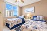 Large windows featuring natural light, neutral textured wall finish, and ceiling-mounted fan with light fixture
