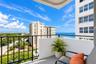 Private balcony featuring black metal railings, solid partition walls, and expansive ocean and coastal scenery