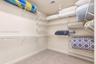 Storage area featuring wall-to-wall white wire shelving and neutral carpeting