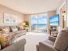 Sliding glass doors providing access to a private balcony with ocean frontage