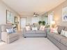 Neutral-toned interior featuring wall-to-wall carpeting, mirrored closet doors, a central ceiling fan with integrated lighting, and multiple louvered-