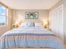 Large window providing natural light, white louvered closet doors, and neutral wall tones