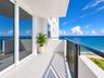 Private balcony featuring a concrete surface, metal railings, and oversized sliding glass doors