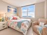 Neutral wall tones, carpeted flooring, and a large multi-pane window featuring an ocean horizon backdrop