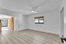 Light wood-finish flooring with white walls and a contemporary ceiling fan
