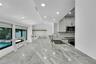 Kitchen featuring a large light-toned countertop, stainless steel sink with a gooseneck faucet, white cabinetry, and stainless steel microwave