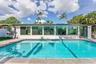 Expansive swimming pool with a tile border, surrounded by a stone paver deck