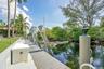 Waterfront dock with boat lift, integrated dock lighting, and lush surrounding foliage