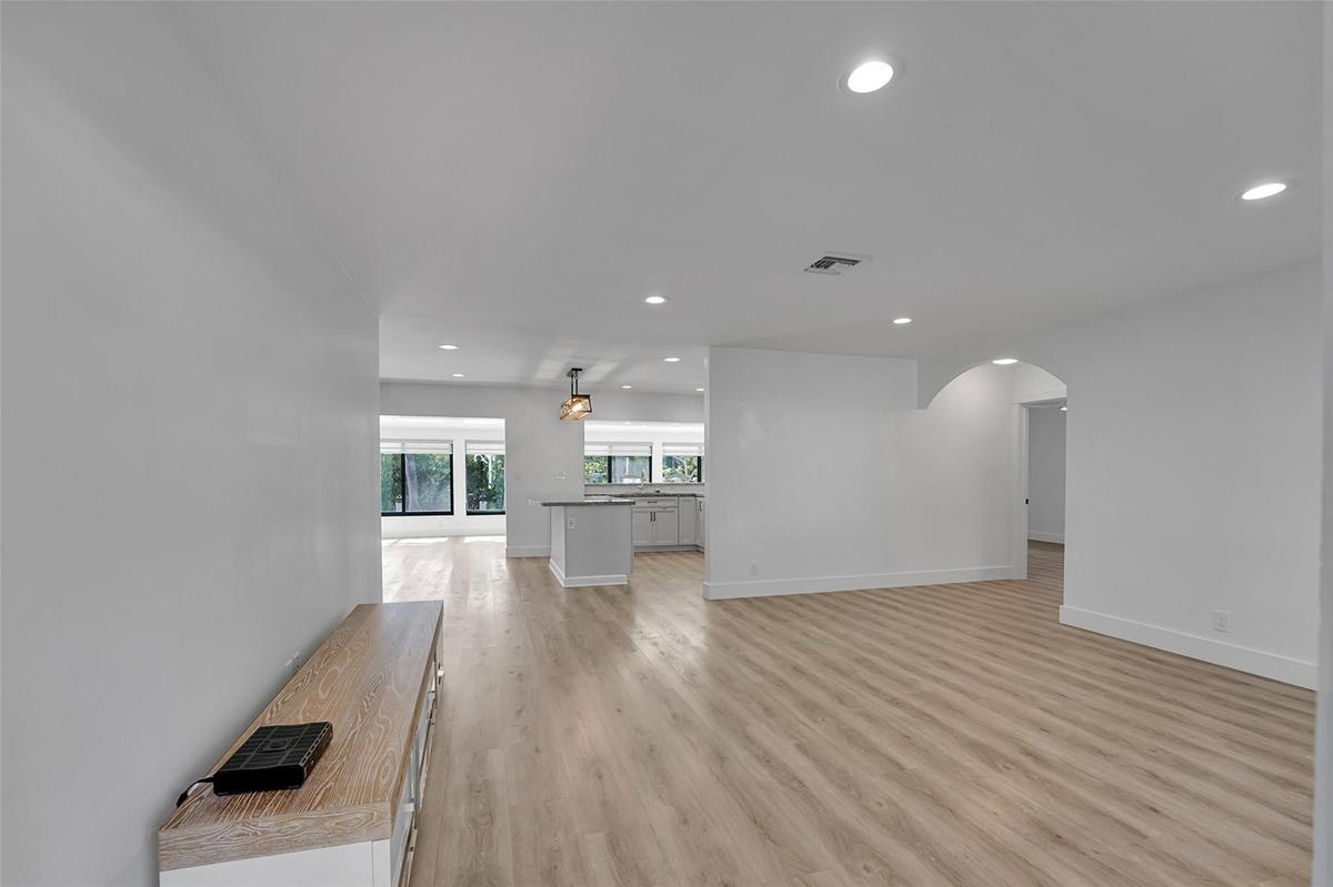 Recessed lighting, wood-finish flooring, and arched entryway