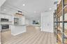 Kitchen featuring stainless steel appliances, light-toned cabinetry, and a central island with a stone countertop