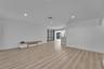 Recessed lighting, light wood-finish flooring, white walls, and a built-in media console
