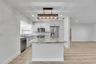 Kitchen featuring a central island with countertop, stainless steel appliances, recessed lighting, and wood-finish flooring