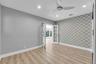 Recessed lighting, wood-finish flooring, accent wall with patterned wallpaper, ceiling fan, and French doors