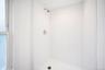 Second floor shower stall featuring white square tile surround, white basin, and polished chrome fixtures