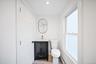 Second floor bathroom featuring dark-finished vanity with gold-tone hardware, rectangular undermount sink, oval wall-mounted mirror, and wood-finish f