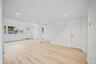 Open-concept interior featuring wood-finish flooring, recessed lighting, and a staircase with white balusters and a decorative post