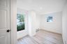Interior space featuring vinyl wood-finish flooring, recessed lighting, dual windows with white casing, and a paneled interior door with matte black h
