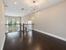 Open loft featuring dark wood-finish flooring, a modern sputnik-style chandelier, recessed lighting, and a wrought-iron staircase railing with an arch