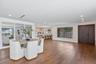 Open-concept interior featuring wood-finish flooring, recessed lighting, a built-in wall mirror, and a solid wood front door