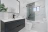 Modern floating vanity with a matte black geometric-patterned finish, white countertop, and black faucet