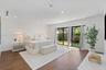 Wide room featuring wood-finish flooring, recessed lighting, and expansive black-framed glass sliding doors opening to exterior grounds